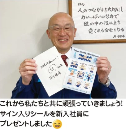 サイン入りシールを持つ社長の写真